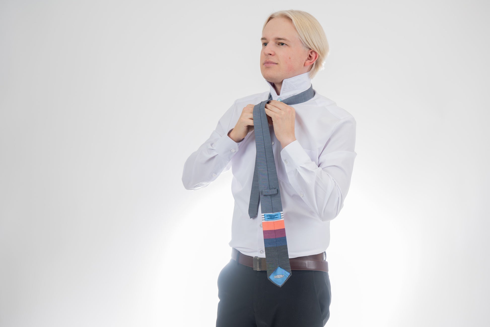 A man wearing a cool, modern necktie with thick coral, purple, and blue stripes