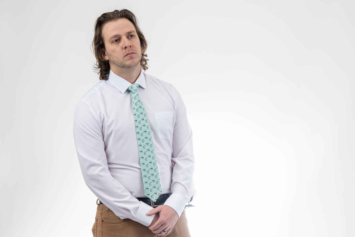 A man wearing a necktie with yetis, skis, and snowboarding
